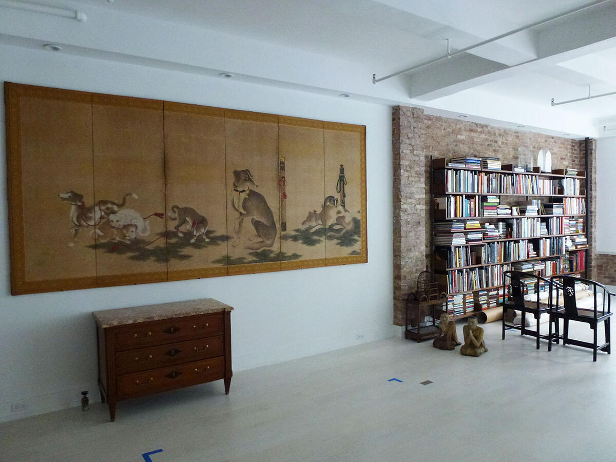 Wall with collage of dogs on brown canvas with a bookshelf to the right