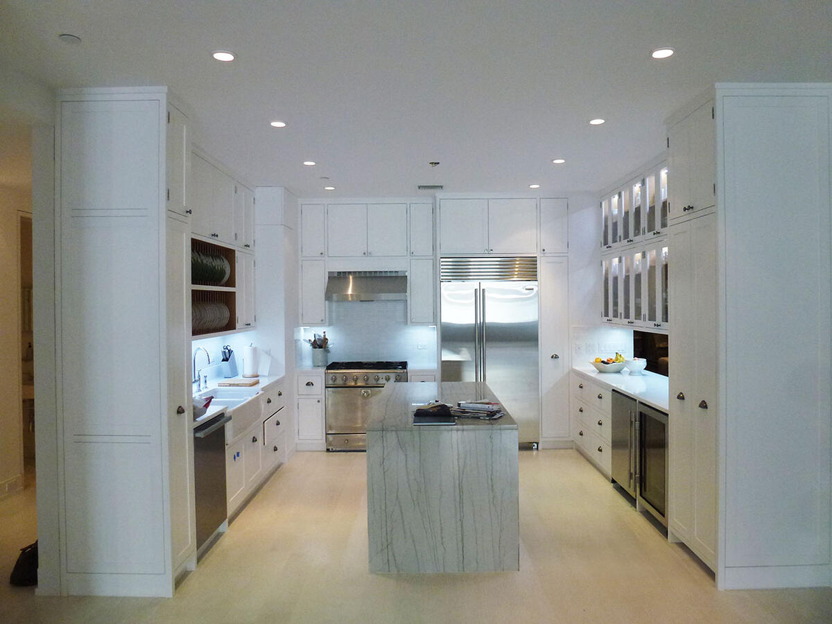 Brightly lit white kitchen with marble counters
