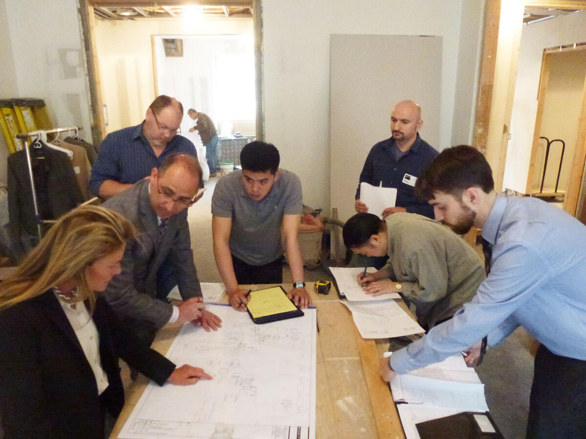 Wall with collage of dogs on brown canvas with a bookshelf to the right